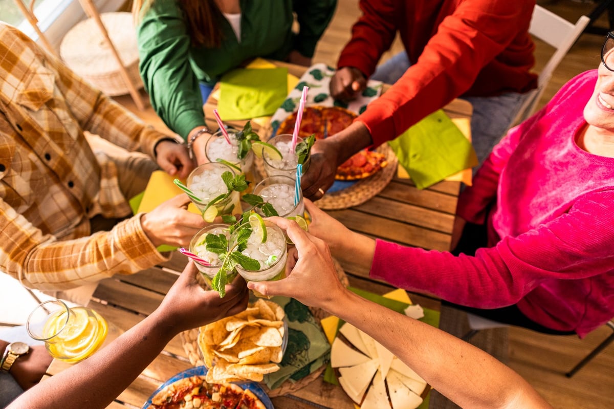 Friends raising glasses in a joyful celebration at Sip Sip