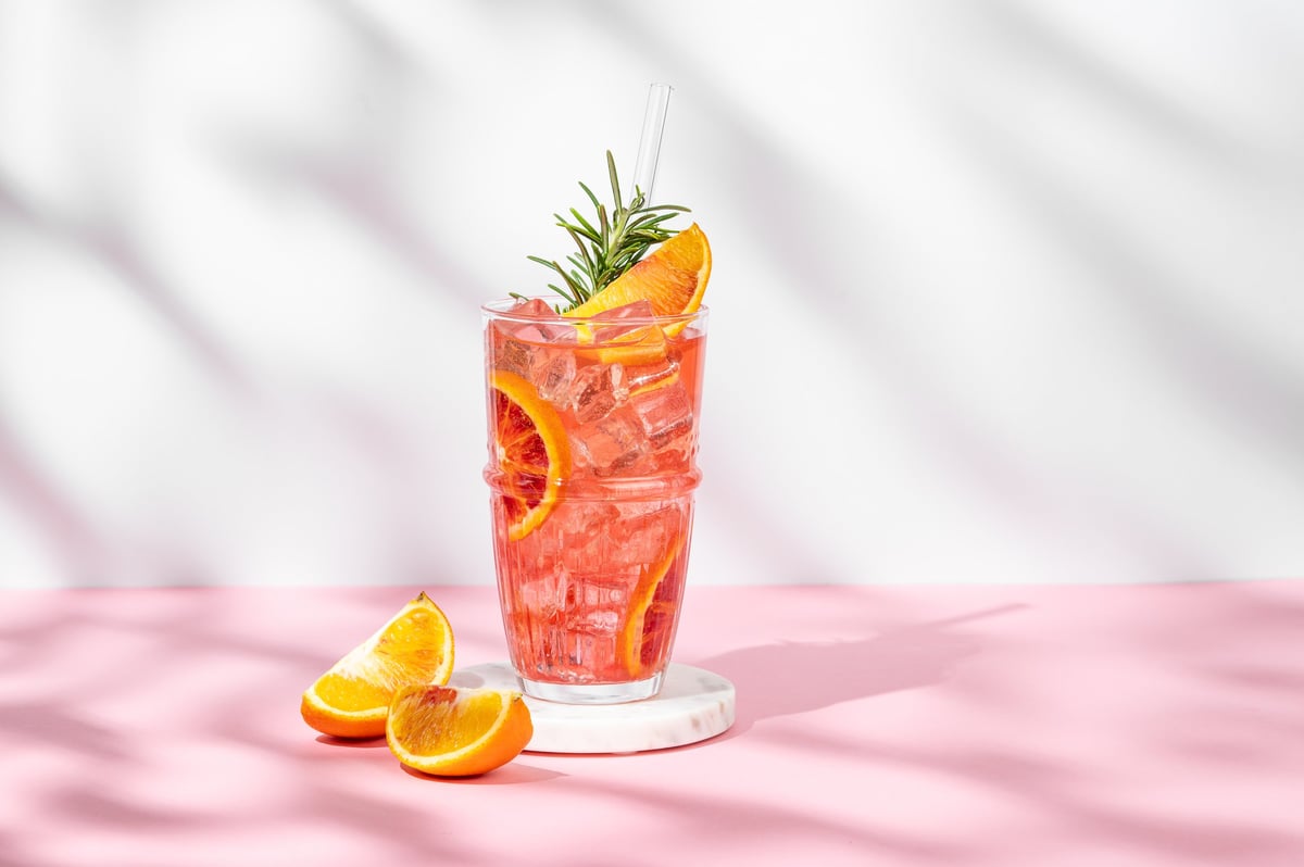 A blood-orange cocktail in vivid coral pink — a splash of Sip Sip colour